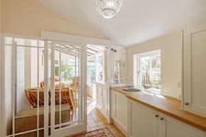 a kitchen with white cabinets and a sink at Coulter Cottage in Earlsferry