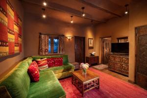 un salon avec un canapé vert et une télévision dans l'établissement The Inn of Five Graces, à Santa Fe