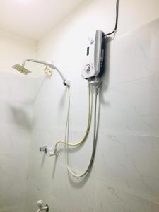 a shower in a bathroom with a phone on the wall at Sakula Villa Inn in Weligama