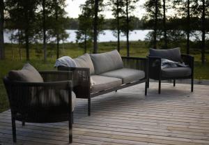 a couch and two chairs sitting on a deck at Modern boende med sjöutsikt in Ryssby
