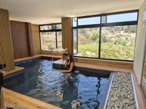a woman is sitting in a pool of water at Ios spa, איוס ספא in ‘Isfiyā