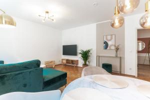 a living room with a green couch and a tv at JAMA - Designapartment im Herzen der Stadt in Schweinfurt
