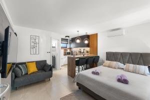 een slaapkamer met een bed en een bank en een keuken bij Apartments Frama Poreč - Funtana in Funtana