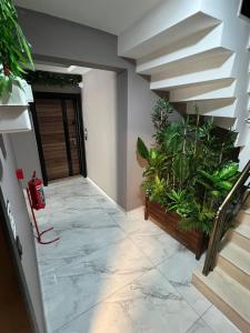 a hallway with stairs and plants in a building at Safran Suit Otel in Buca +14 photos