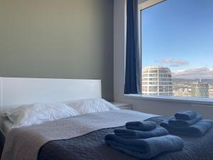 une chambre avec un lit avec des serviettes bleues dessus dans l'établissement SAG 28 floor Panrama city free parking free wifi, à Bratislava