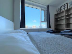 une chambre avec un lit avec une grande fenêtre dans l'établissement SAG 28 floor Panrama city free parking free wifi, à Bratislava