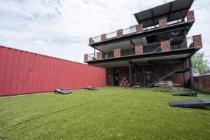 Un edificio con un gran patio con una pared roja. en Sleep24 13Beds 8BR 6BA Swepson Retreat KING, en Louisville