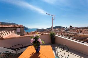 a vase of flowers sitting on a table on a balcony at House Star 1 in Dubrovnik