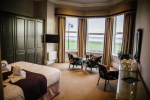 a hotel room with a bed and a table and chairs at Clifton Arms Hotel in Lytham St Annes