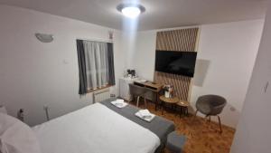 a bedroom with a bed and a desk and a television at Olimpus Apartmani BD Banjaluka in Banja Luka +90 photos