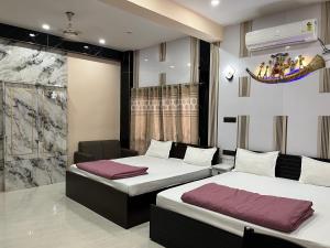 ein Schlafzimmer mit zwei Betten in einem Zimmer in der Unterkunft Hotel Krishna Paradise in Deoghar