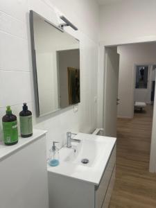 een witte badkamer met een wastafel en een spiegel bij Concerti, Stadio e Aeroporto Bologna in Bologna