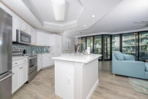 una cucina con armadi bianchi e un divano blu di Phoenix on the Bay 1223 condo a Orange Beach