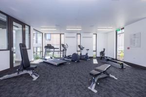 a gym with several treadmills and machines in a room at Penthouse with Marina Views - Studio or Two Bedroom Apartment in Wanaka