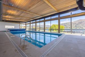 a large swimming pool with a view of the mountains at Penthouse with Marina Views - Studio or Two Bedroom Apartment in Wanaka