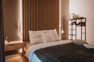 a bedroom with a bed with white pillows at Enklawa - Apartamenty z balią w otoczeniu natury in Nowy Podleś