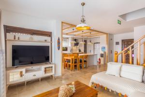 Una sala de estar con un sofá y un televisor. en White Garden Villas, en Kas
