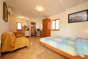 a bedroom with a bed and a chair in it at Guest House AB Adria Home in Rovinj