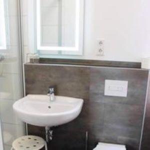 a bathroom with a sink and a mirror at Hotel Restaurant Harrier Hof in Brake +5 photos