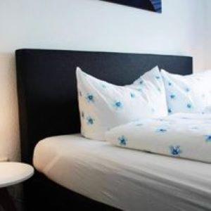 a bed with white pillows and a black head board at Hotel Restaurant Harrier Hof in Brake