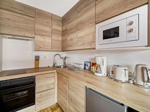 - une cuisine avec des placards en bois et un four micro-ondes dans l'établissement RB111 - Studio 4 Pers centre Carroz, aux Carroz d'Arâches