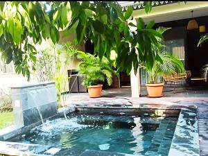 a pool in the backyard of a house with plants at Villa Les Jardins de la Trinité in Saint-Philippe