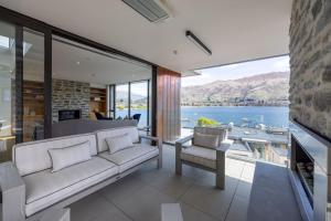 a living room with a couch and a view of a lake at Penthouse with Marina Views - Studio or Two Bedroom Apartment in Wanaka