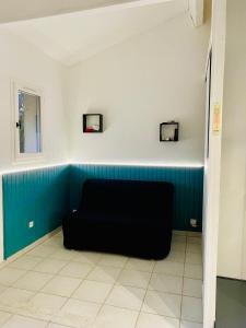 czarna kanapa w pokoju z niebieską ścianą w obiekcie Villa Domaine des Pins, Magasins proches, Piscine w Fréjus +6 zdjęć