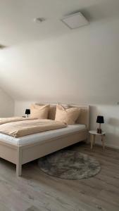 a bedroom with a bed with two lamps and a rug at Stilvolles Apartment in Schweinfurt
