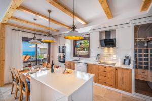 una cocina con una gran encimera blanca y armarios de madera en White Garden Villas, en Kas