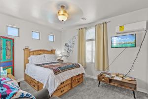 Un dormitorio con una cama y un televisor en la pared. en Cozy Casita Suite, en Las Cruces