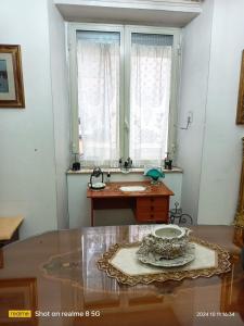 Habitación con mesa de cristal y ventana. en Da Francy B&b, en Nápoles