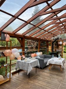a pergola with two tables and a couch on a deck at Noclegi ECHO in Smardzewice