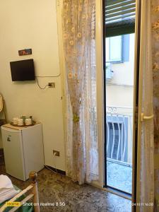 Habitación con puerta corredera de cristal y ventana en Da Francy B&b, en Nápoles