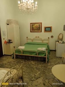 Un dormitorio con una cama verde y una lámpara de araña. en Da Francy B&b, en Nápoles