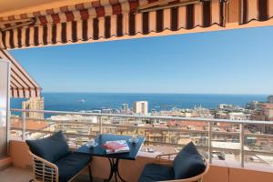 a balcony with a table and chairs and a view at Luxury Monte Carlo- Seaview, Champagne & AC in Beausoleil