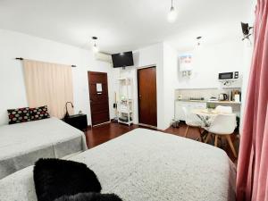 a living room with two beds and a table at 866 Apart in San Fernando del Valle de Catamarca