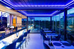a restaurant with tables and chairs and a bar at J Maluni City Hotel in Rome