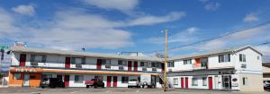 a large white building with red and white trim at American Inn Motel Canon City in Canon City