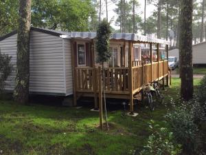 drewniany domek na dziedzińcu z drzewami w obiekcie MH 557 TOUT confort 40m2 3ch dont suite parentale 2 salles de bain avec vue sur forêt dans camping 4 étoiles w mieście Saint-Julien-en-Born