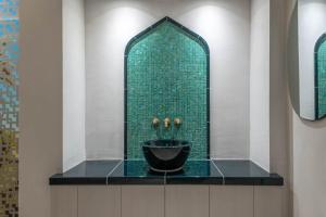 a bathroom with a sink and a green wall at Parkhotel Flora in Bad Grund