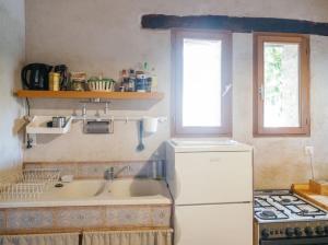 eine Küche mit Spüle und einem weißen Kühlschrank in der Unterkunft Cute stone cottage in Provence in Rivest-Saint-Martin + 28 Fotos