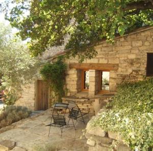 einen Tisch und Stühle vor einem Steingebäude in der Unterkunft Cute stone cottage in Provence in Rivest-Saint-Martin