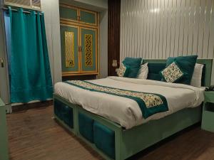Schlafzimmer mit einem großen Bett und blauen Vorhängen in der Unterkunft Hi hotel By Madras in Rishikesh