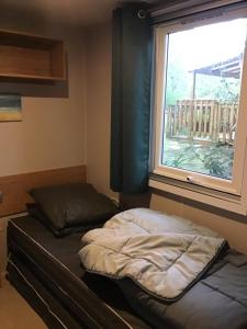 pokój z łóżkiem i oknem w obiekcie MH 557 TOUT confort 40m2 3ch dont suite parentale 2 salles de bain avec vue sur forêt dans camping 4 étoiles w mieście Saint-Julien-en-Born +24 zdjęcia