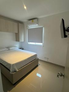 Un dormitorio con una cama y una ventana. en Apartamentos Cartagena Acuarium, en Cartagena de Indias 2 fotos más
