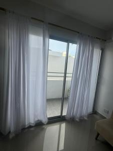 una habitación con una ventana con cortinas blancas en Apartamentos Cartagena Acuarium, en Cartagena de Indias