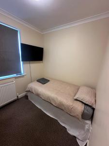 Un pequeño dormitorio con una cama en la esquina en Large 5 bedroom property in the centre with lots of parking, en Boston