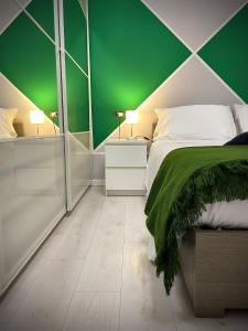 a green and white bedroom with a bed and two lamps at 22CAP apartment in Milan