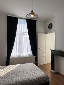a bedroom with a bed and a large window at Studio Nahida in Brussels